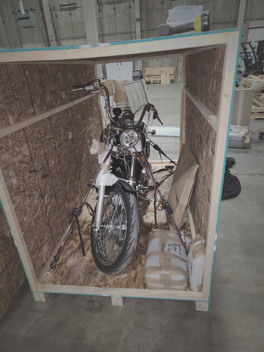 A chrome cruiser strapped and cross-braced inside an open wood crate