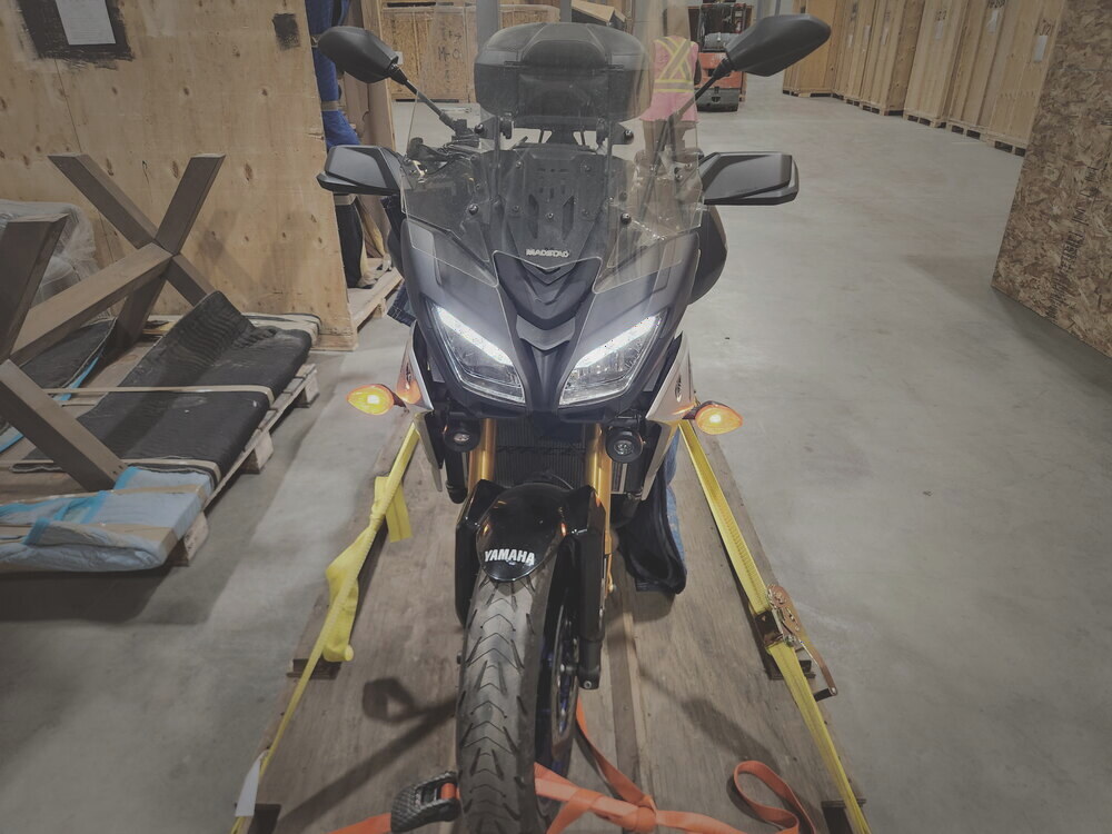 A Yamaha motorcycle on a shop lift before crating, seen from the front