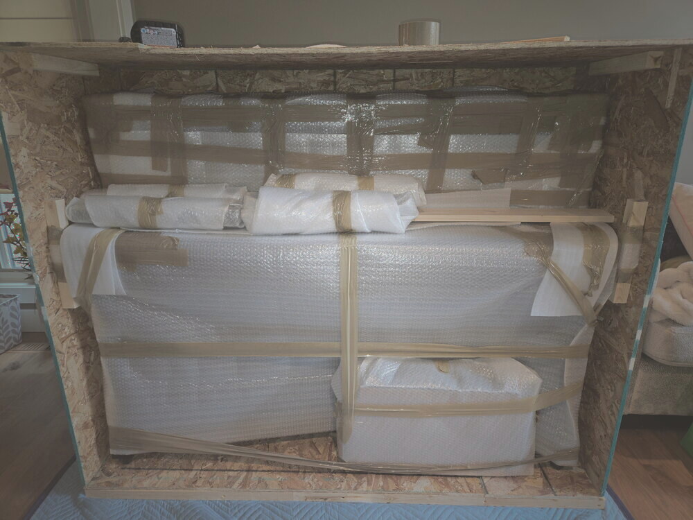 The wrapped piano fully strapped and cross-braced inside its crate